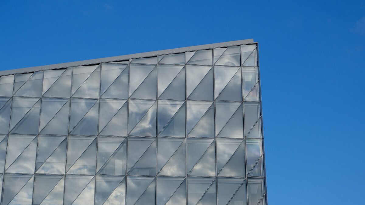 Glass exterior of JTI's headquarters in Geneva, Switzerland, against a blue sky