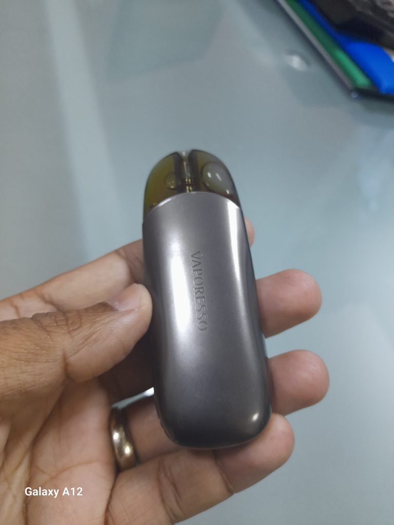 A hand holding a silver VAPORESSO ZERO 2 with a dark translucent pod.