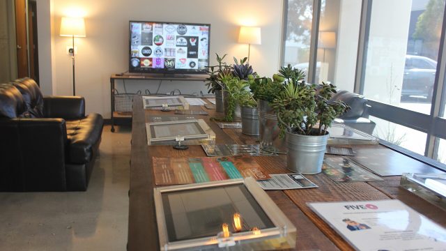 Interior of a vape shop with a display counter, plants and a lounge area