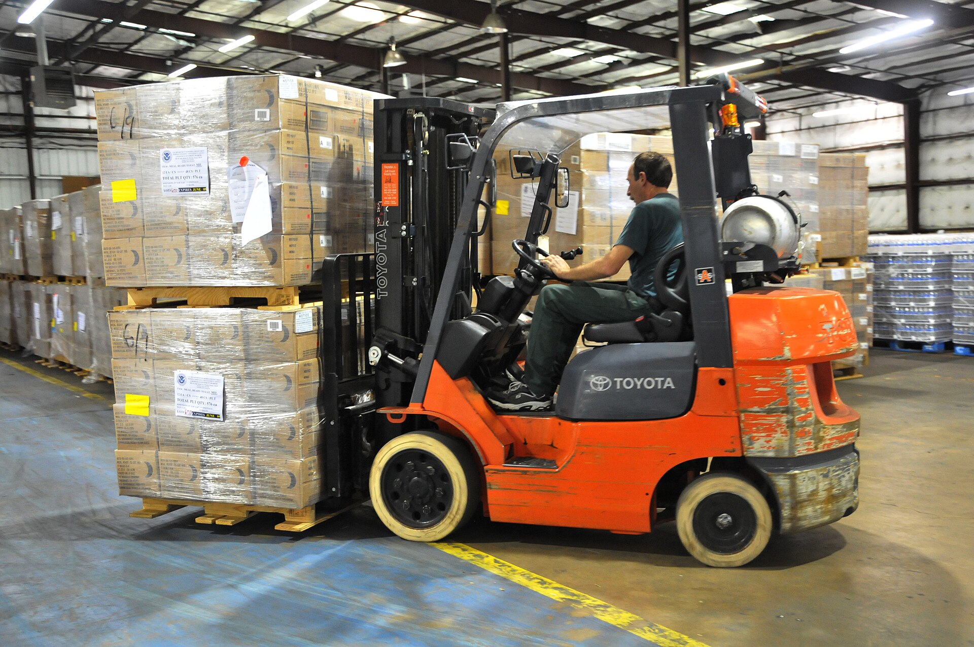 A worker moving supplies by forklift inside a warehouse in Tyler, Texas